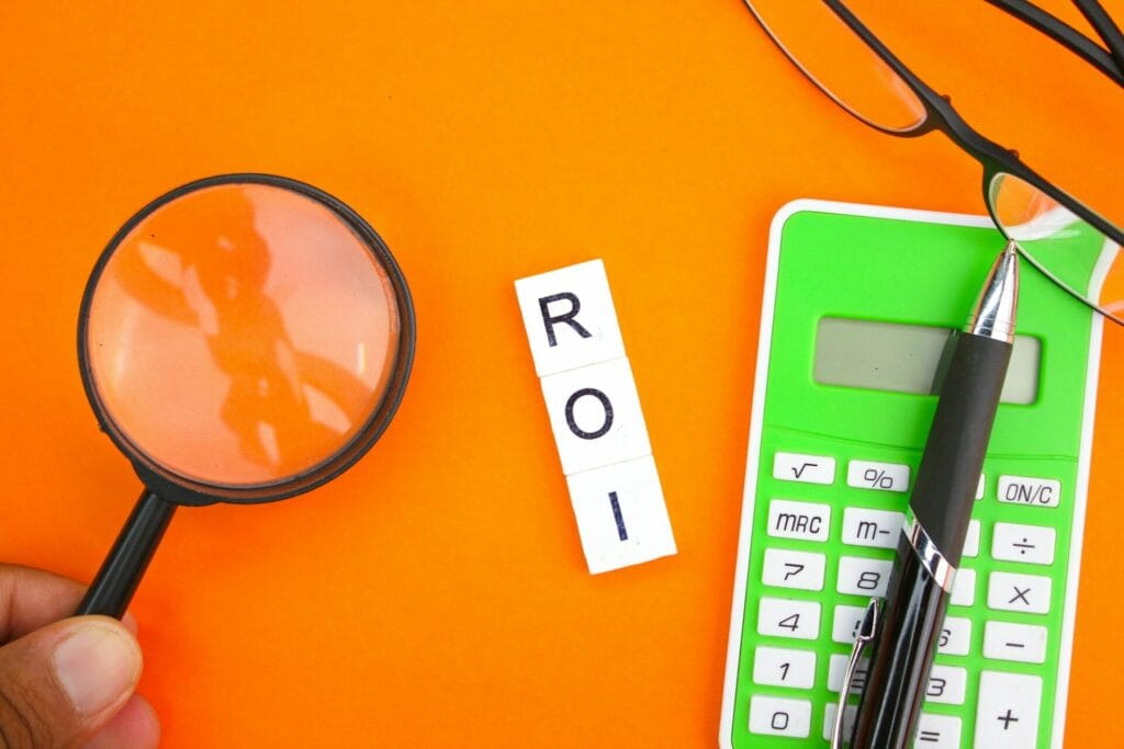 calculator, pen, magnifying lens and glasses with the letters ROI